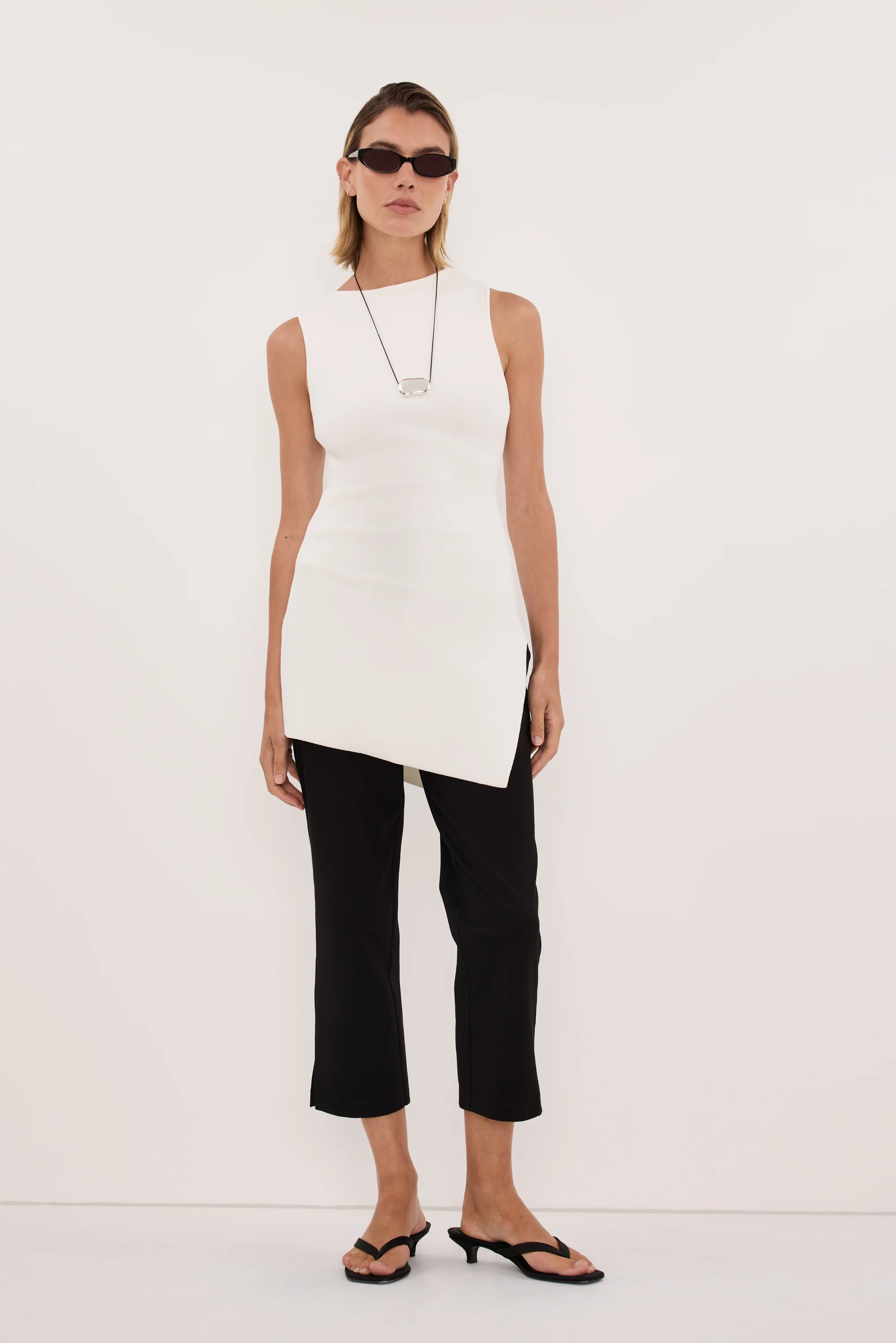 CLEO WHITE SLEEVELESS LONGLINE KNIT TOPĀ